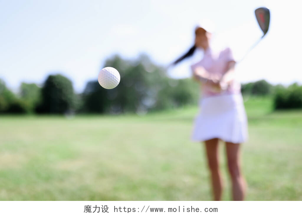 女孩在球场打高尔夫球打女子特写镜头背景下的高尔夫球
